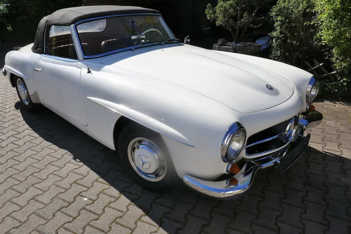 Weißer Mercedes-Benz 190 SL Roadster auf einem gepflasterten Hof